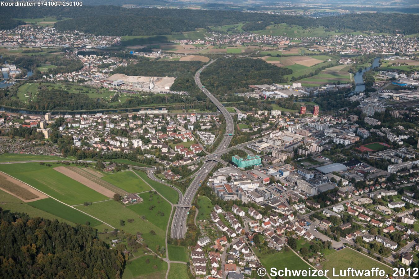 Doppelstöckige Kreuzung Urdorf-Nord (Position 2'673'907.43, 1'249'750.55): Autobahn A3/A4 und Bernstrasse. Am rechten Bildrand Mitte: Kantonsschule Limmattal. - Kiesgrube 'Hard' (Fahrweid). Bildmitte hinten: Weiningen (ZH), westlich davon Geroldswil, östlich Unterengstringen. Bildhintergrund: Regensdorf